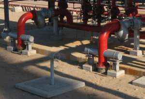 Typical above-ground carbon steel piping with dummy-leg supports at a valve house, as assumed in the analysis.
